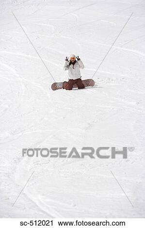 Stock Image - Snowboarder giving peace sign. Fotosearch