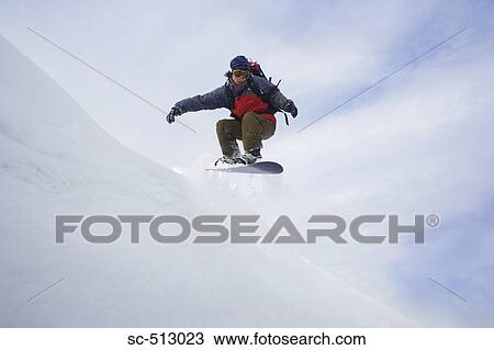 Stock Image - Snowboarder mid air. Fotosearch