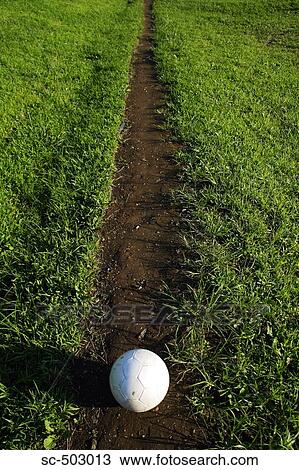 Stock Image - Soccer Ball Lying On a Footpath. Fotosearch