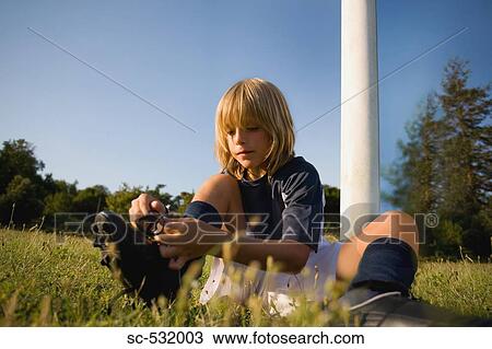 Stock Image - Soccer boy tying his shoelaces. Fotosearch