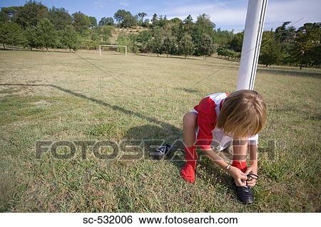 Soccer boy tying his shoelaces View Large Photo Image Stock Photograph - Soccer boy tying his shoelaces. Fotosearch