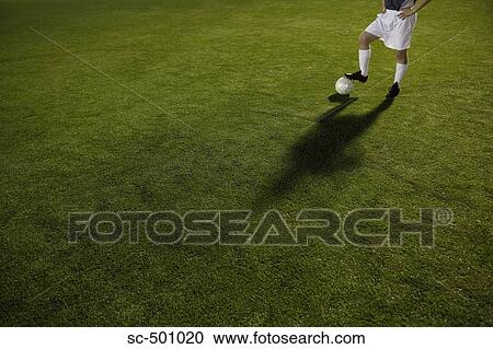 Stock Image - Soccer Player and Ball Standing In Open Field. Fotosearch