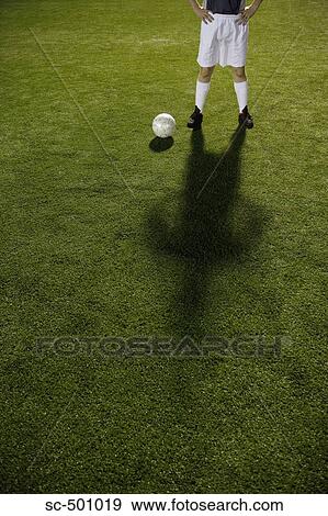 Stock Photo - Soccer Player and Ball Standing In Open Field. Fotosearch