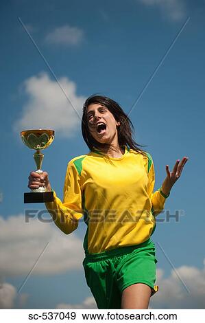 Soccer player celebrating with a trophy View Large Photo Image Stock Photo - Soccer player celebrating with a trophy. Fotosearch