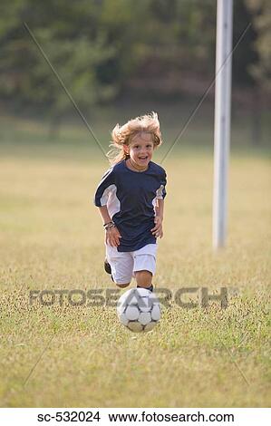Picture - Soccer player cheering and about to kick football. Fotosearch