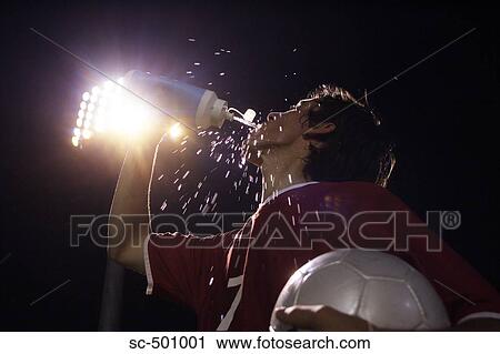 Soccer Player Drinking Water Against Lights View Large Photo Image Stock Image - Soccer Player Drinking Water Against Lights. Fotosearch