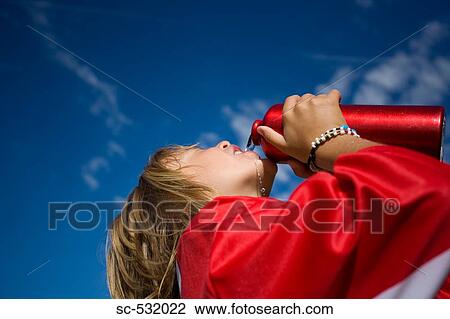 Soccer player drinking water against blue sky View Large Photo Image Stock Image - Soccer player drinking water against blue sky . Fotosearch