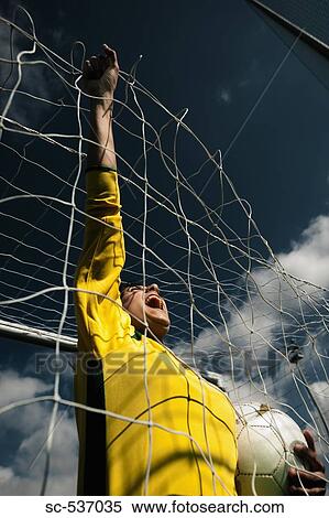 Stock Photography - Soccer player holding soccer ball. Fotosearch