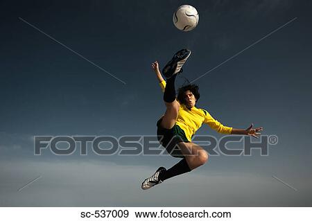 Soccer player in mid-air doing scissor kick View Large Photo Image Stock Photo - Soccer player in mid-air doing scissor kick. Fotosearch