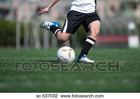 Soccer player kicking soccer ball View Large Photo Image Stock Image - Soccer player kicking soccer ball. Fotosearch