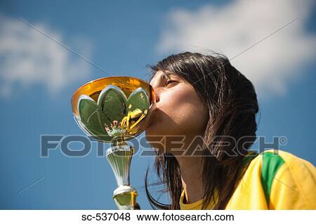 Stock Photo - Soccer player kissing trophy. Fotosearch