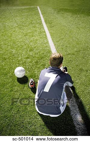 Picture - Soccer Player Lacing Shoes By Sidelines. Fotosearch