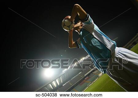 Stock Photo - Soccer Player Raising Ball In Victory. Fotosearch