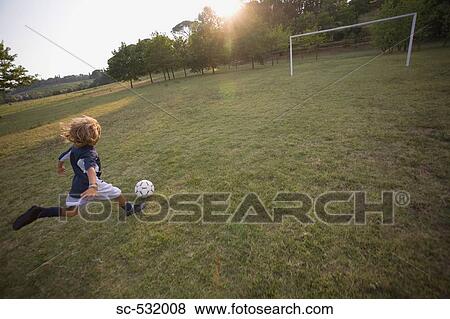 Soccer player running after football View Large Photo Image Stock Photo - Soccer player running after football. Fotosearch