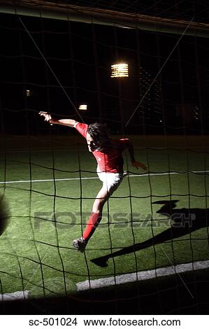 Picture - Soccer Player Running Past Net. Fotosearch