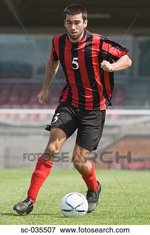 Stock Photo - Soccer player running with ball. Fotosearch