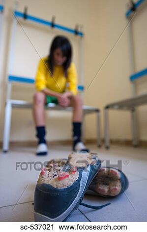 Stock Image - Soccer player sitting in room. Fotosearch
