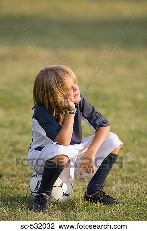 Soccer player sitting on football View Large Photo Image Stock Image - Soccer player sitting on football. Fotosearch