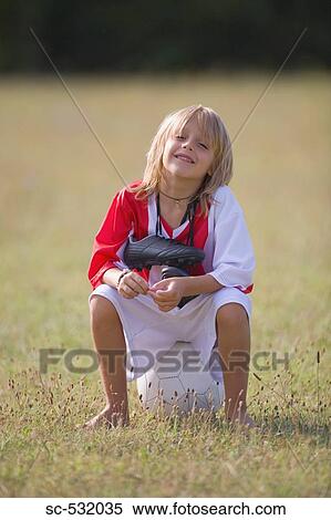 Soccer player sitting on football View Large Photo Image Stock Photography - Soccer player sitting on football. Fotosearch