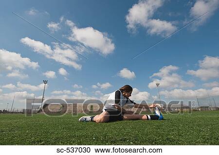 Stock Image - Soccer player stretching . Fotosearch