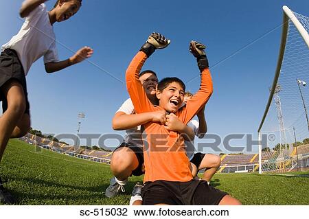 Stock Image - Team hugging their goal keeper. Fotosearch