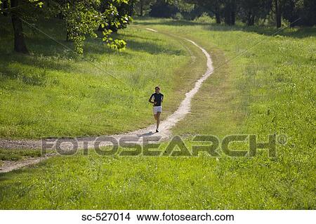 Picture - Teenage Girl Running on a Dirt Track. Fotosearch