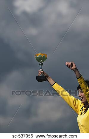 Stock Photograph - Teenager player holding trophy. Fotosearch