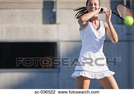 Stock Image - Tennis player hitting forehand return. Fotosearch