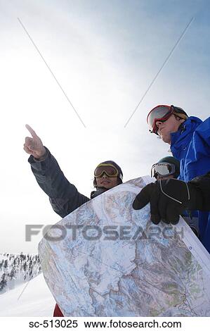 Stock Photography - Three snowboarders with map. Fotosearch