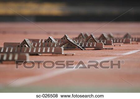 Stock Photo - Track and field starting blocks at starting line. Fotosearch