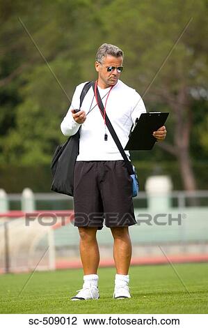 Trainer in sunglasses checking clipboard View Large Photo Image Stock Image - Trainer in sunglasses checking clipboard. Fotosearch