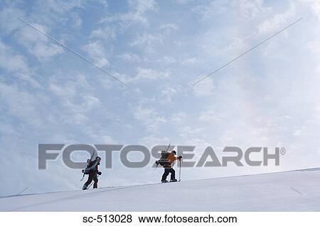 Stock Photo - Two snowboarders trudging through snow. Fotosearch