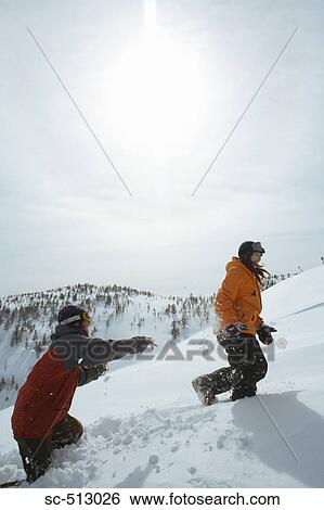 Stock Photograph - Two snowboarders trudging through snow. Fotosearch