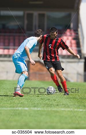 Two soccer players challenging for the ball View Large Photo Image Picture - Two soccer players challenging for the ball. Fotosearch