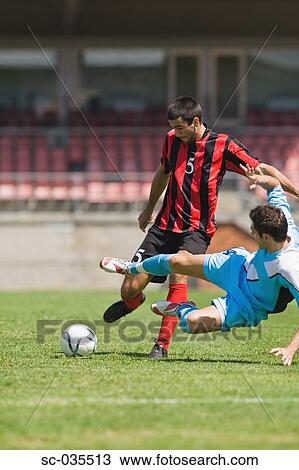 Stock Image - Two soccer players challenging for the ball. Fotosearch
