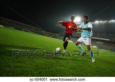 Stock Image - Two Soccer Players Chasing A Ball. Fotosearch