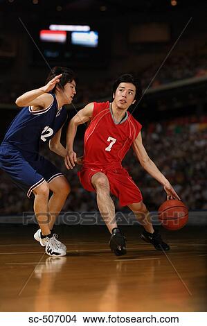 Picture - Two young Asian basketball players competing. Fotosearch