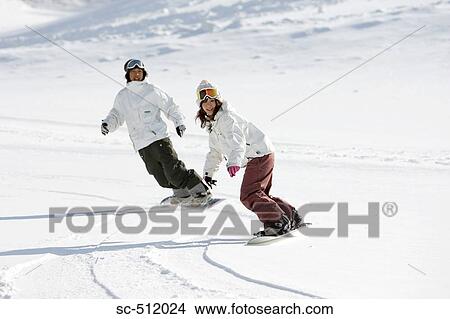 Picture - Two young Asian snowboarders in action. Fotosearch