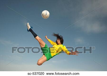 Woman hitting soccer ball doing scissor kick View Large Photo Image Stock Image - Woman hitting soccer ball doing scissor kick . Fotosearch