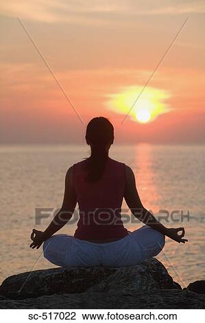 Stock Image - Woman Meditating Near the Sea. Fotosearch
