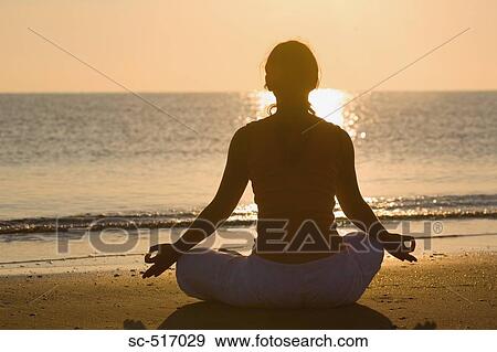 Stock Photo - Woman Meditating On the Beach. Fotosearch