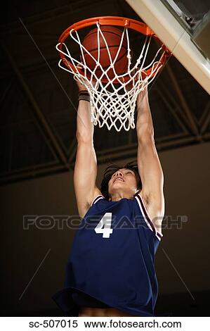 Stock Photography - Young Asian basketball player making a dunk. Fotosearch