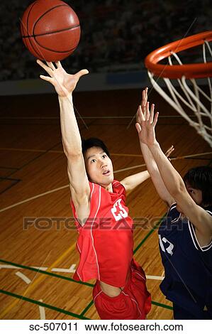 Stock Image - Young Asian basketball players on court. Fotosearch