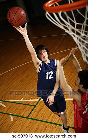 Stock Image - Young Asian basketball players on court. Fotosearch