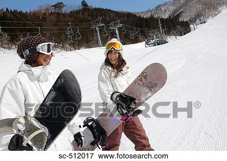 Stock Photo - Young Asian couple with snowboards. Fotosearch