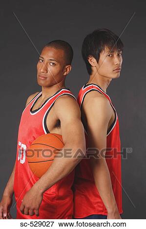 Stock Photo - Young basketball players standing back to back. Fotosearch
