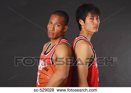 Stock Photo - Young basketball players standing back to back. Fotosearch