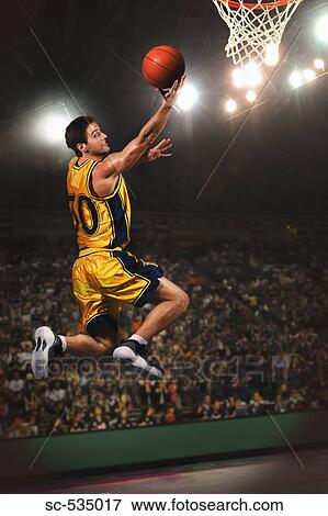 Young man jumping and holding basketball View Large Photo Image Stock Photo - Young man jumping and holding basketball . Fotosearch