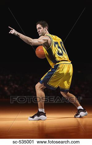 Stock Image - Young man playing basketball. Fotosearch