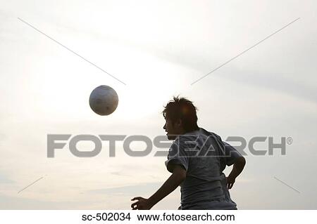 Picture - Young Man Playing Soccer On A Beach. Fotosearch